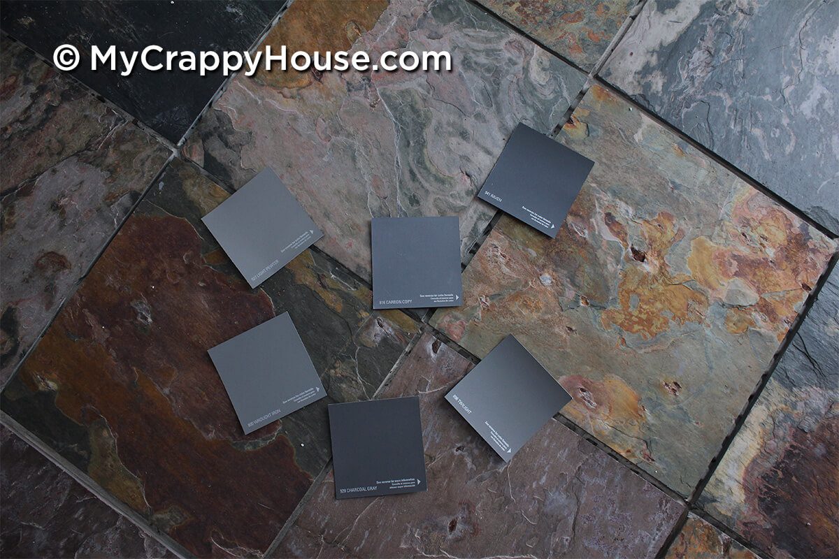Grout color swatches arranged on top of slate tile floor