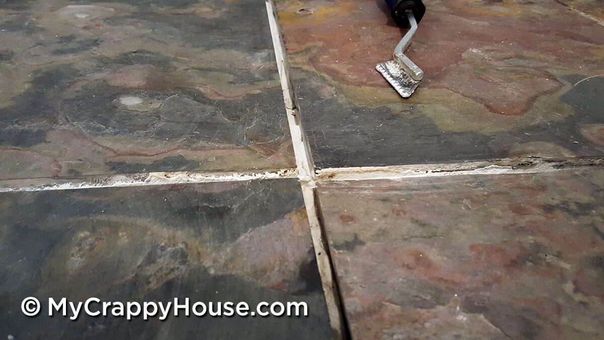 Close up of four slate tiles with messy glue in between