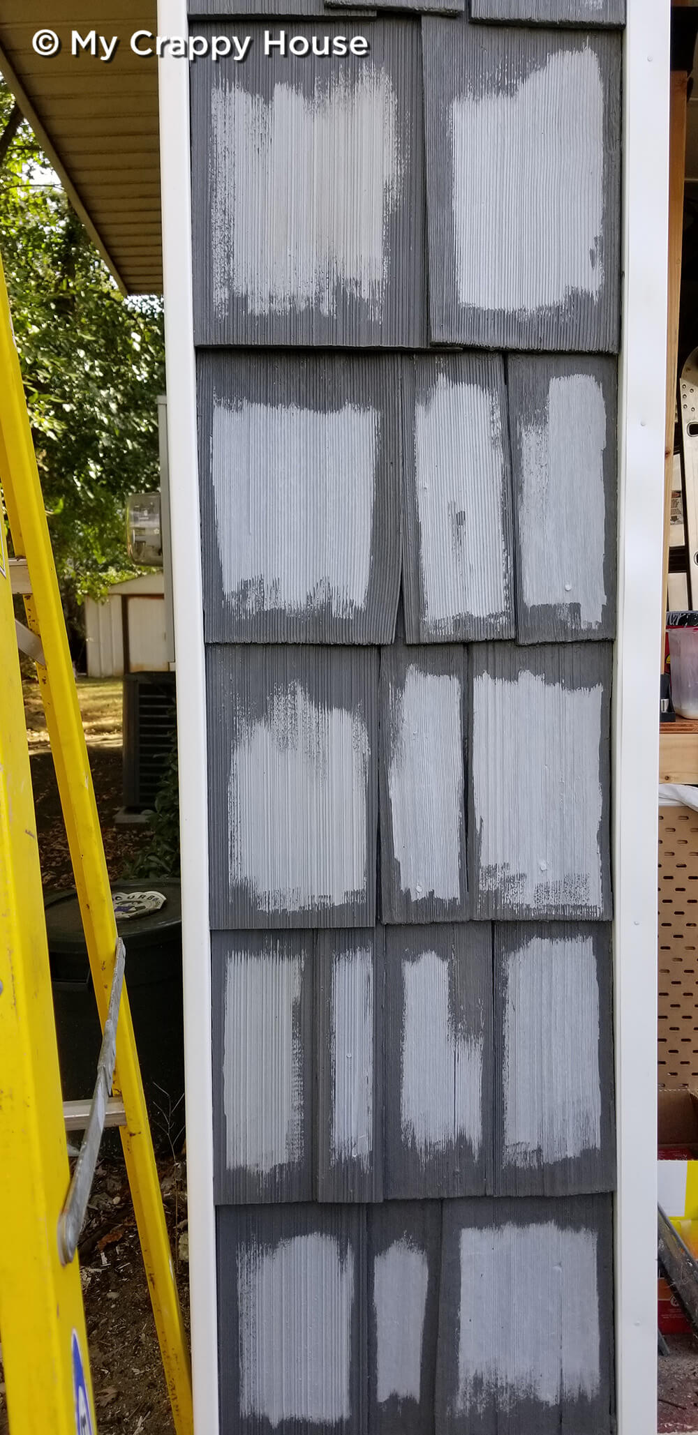 Cedar shingles with dark gray paint cutting in around edges
