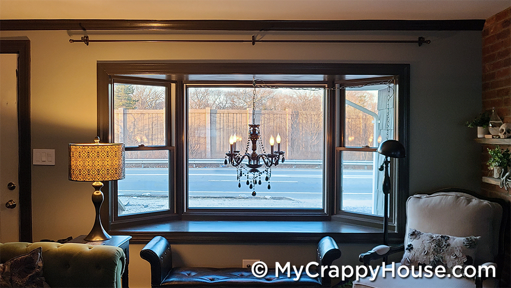 Chandelier in a bay window with dark painted trim