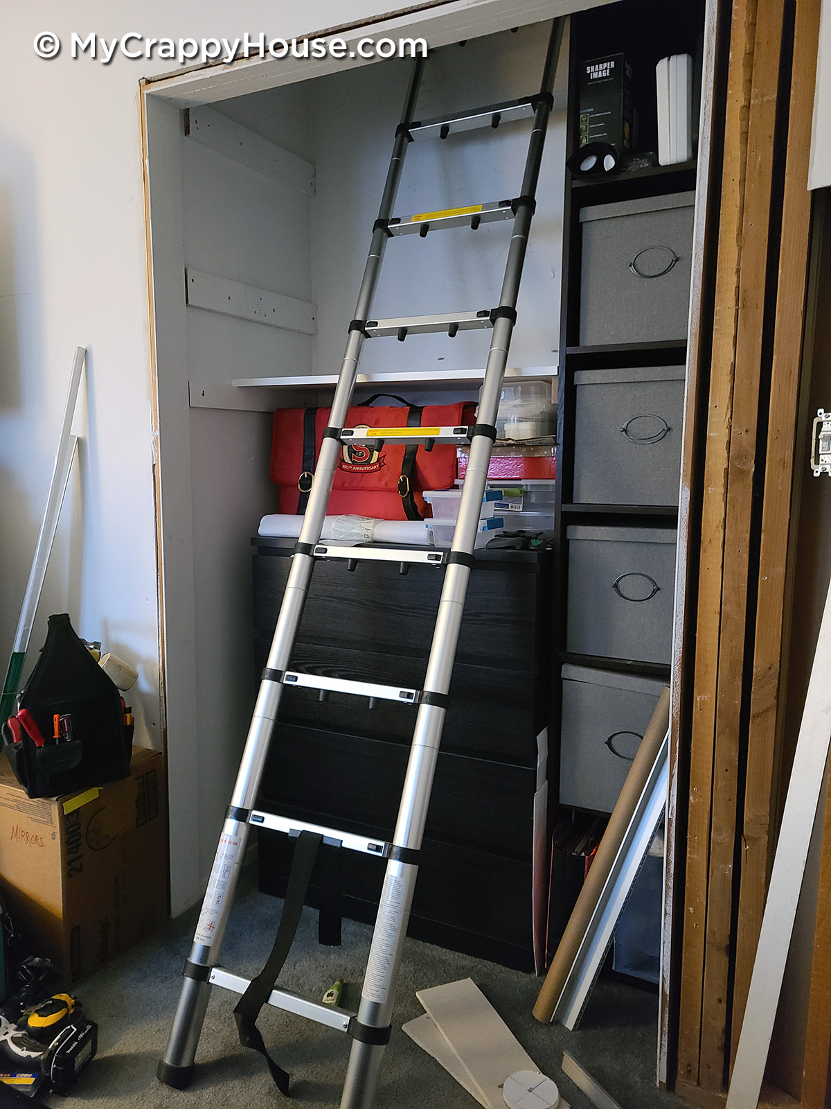 Ladder positioned to climb into an attic in the closet