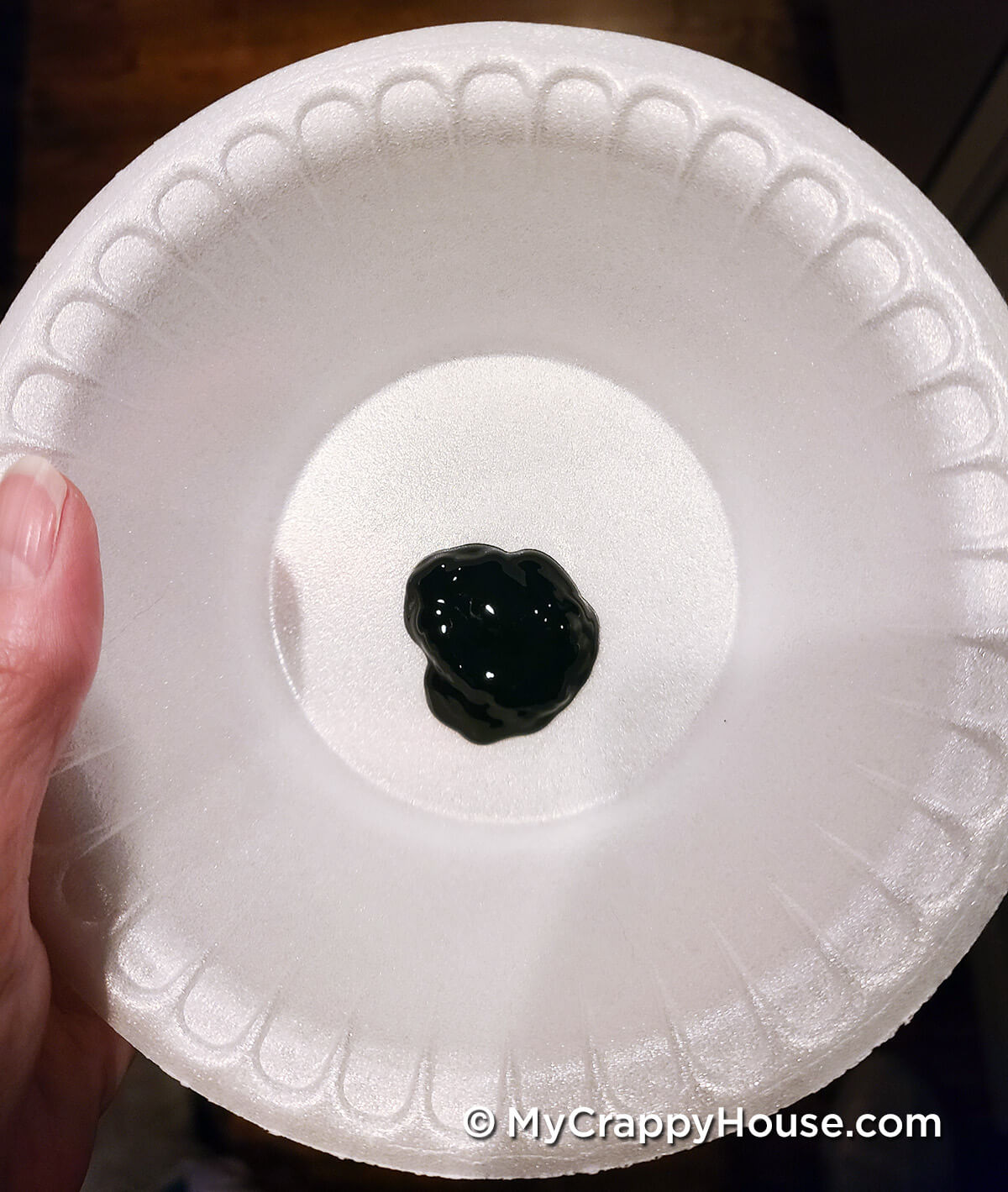 Dab of black paint in a disposable bowl