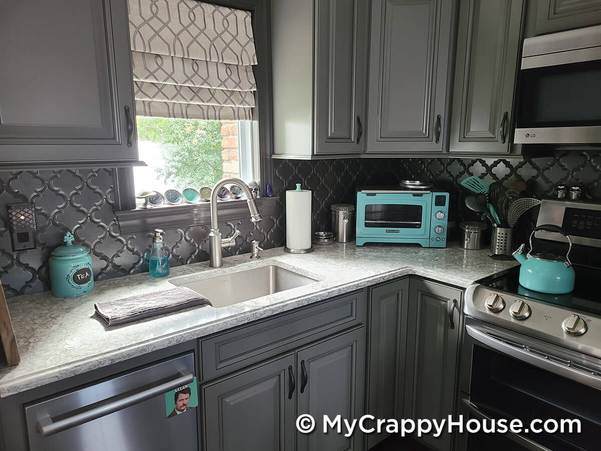 Gray kitchen with aqua sky accessories and quartz counters