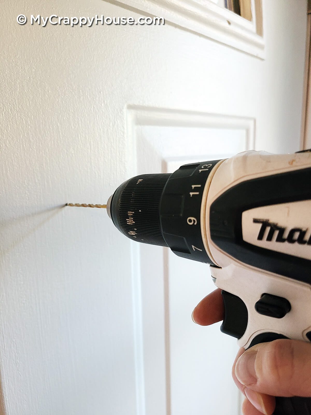 Drilling pilot hole into door to install peephole