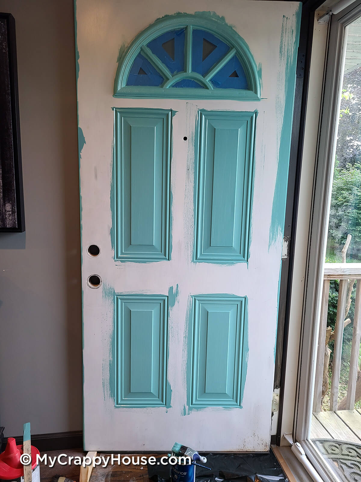 Front door with all panels and window trim painted aqua sky