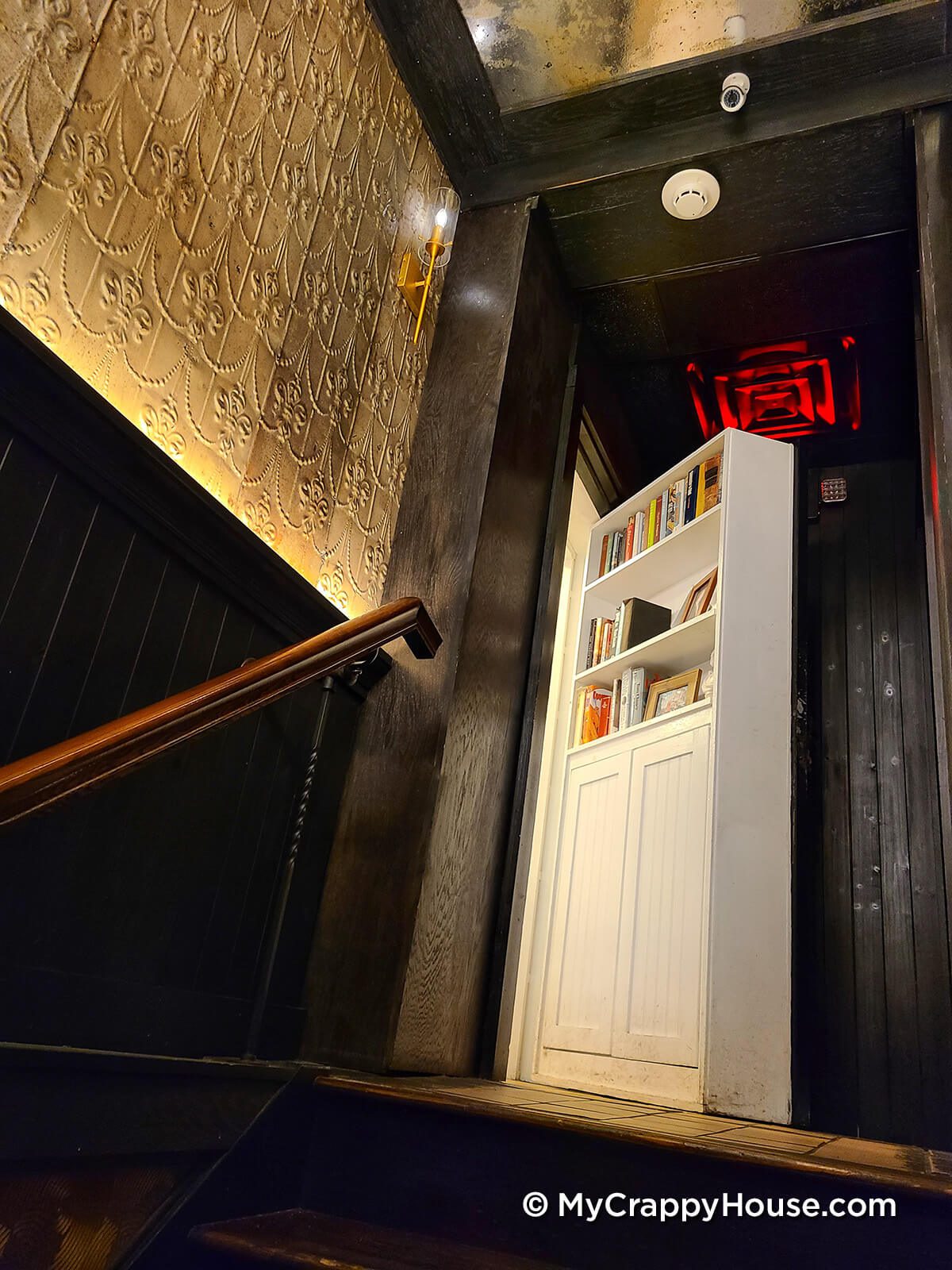 Secret bookcase door in speakeasy opened to hidden stairs