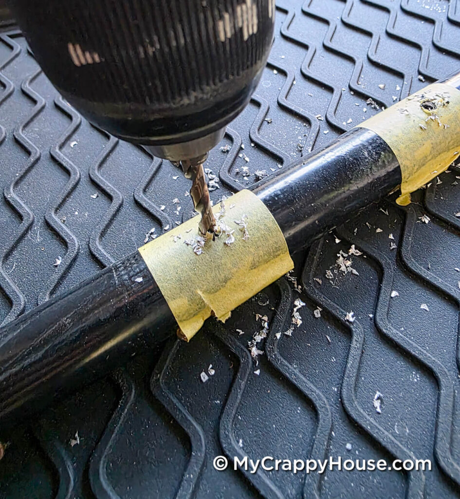 Drilling through masking tape into a metal seat frame to make a hole for a webbing clip.
