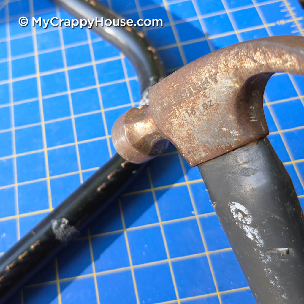 Hammering old webbing staples flat against the metal seat frame instead of removing them.